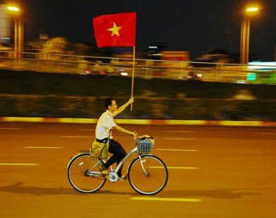 Hình ảnh thiếu niên đạp xe cầm quốc kỳ gây xúc động cộng đồng mạng