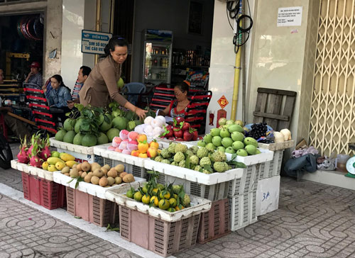 Một người dân bán trái cây trên đường Kinh Dương Vương, quận Bình Tân, TP HCM kinh doanh bên trong vạch sơn Ảnh: Lê Phong