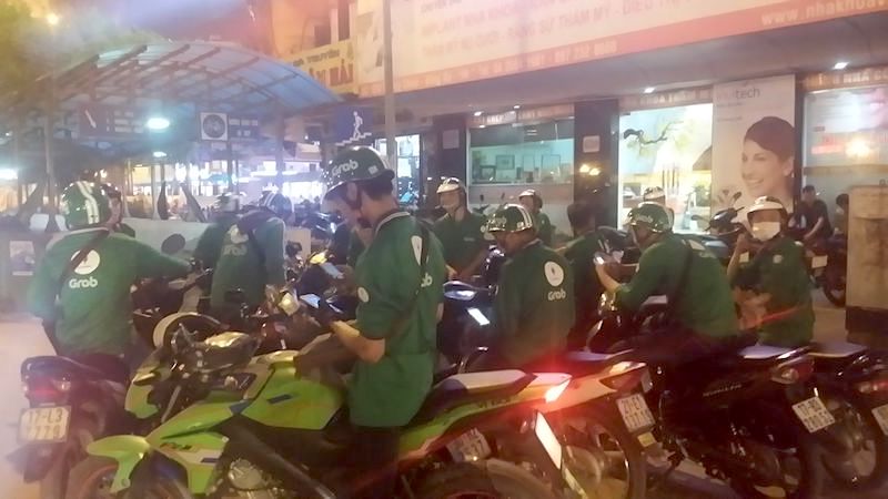 Nhóm tài xế Grab tụ tập nhau tại khu vực Ngã tư sở để tìm kiếm người đàn ông hành hung tài xế Grab.