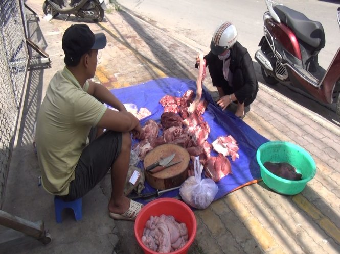 Một người chăn nuôi tại Đồng Nai tự tổ chức giết mổ heo rồi đưa thịt lên bày bán tại một vỉa hè ở TP.HCM - Ảnh: HOÀNG LỘC