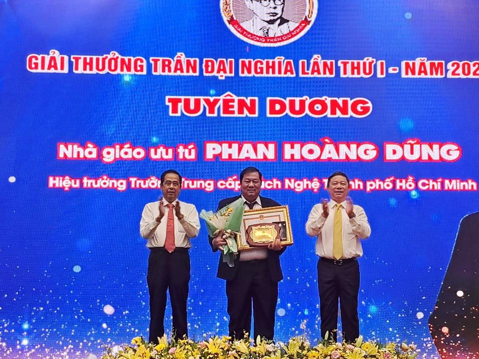 Phó Chủ tịch UBND TP Hồ Chí Minh Dương Anh Đức (bên phải) cùng Phó Giám đốc Sở LĐTB&XH Nguyễn Văn Lâm trao chứng nhận Giải thưởng Trần Đại Nghĩa cho Nhà giáo ưu tú Phan Hoàng Dũng.