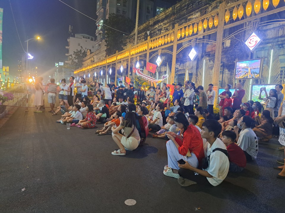 Lý do phải ngồi bệt trên lòng đường xem khai mạc qua màn hình vì chỉ có người có thẻ do Ban Tổ chức phát, mới được vào khu vực chính. Ảnh: Tân Tiến.