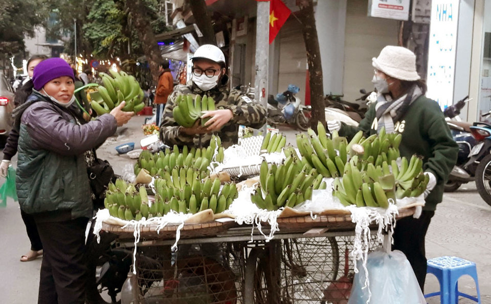 Người tiêu dùng mua chuối xanh tại chợ Gò Đống Đa ngày 29 Tết. Ảnh: Hoài Nam